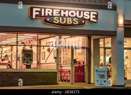Charlotte, NC/USA - 15. November 2019: Horizontaler Schuss von "Firehouse Subs"-Sandwich-Shop mit Marke/Logo mit leuchtem Schild und hell leuchtender Innenausstattung. Stockfoto