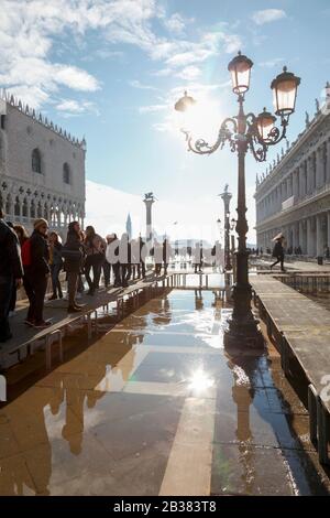 Menschen auf den Gangarten während der Acqua Alta; Piazza di San Marco; Venedig; Venetien; Italien; Europa Stockfoto