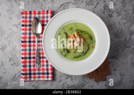 Grüner Spargel Suppe mit Crackern in Weiß Schüssel Nahaufnahme. Essen Fotografie Stockfoto
