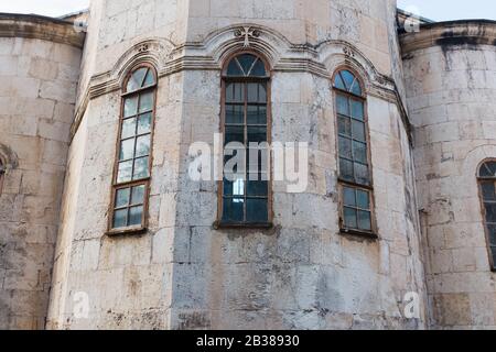 Schmale Senkrechte blaue Fenster der Kirche, die Burg mit einer Mauer aus grauem alten Backstein. Element der historischen Architektur Stockfoto