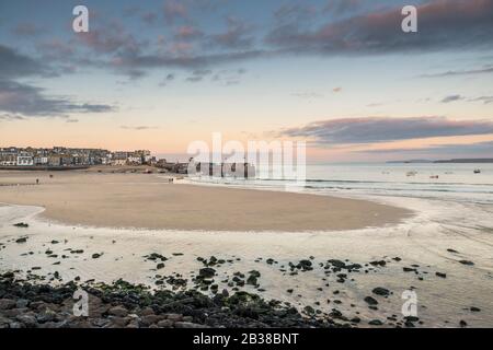 Sonnenuntergang am Harbour Beach, St. Ives, Cornwall bei Ebbe. Stockfoto