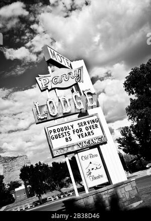 Schwarze und weiße Neon-Zeichen auf der Straßenseite mit dramatischen Wolken über dem Kanab Utah USA Stockfoto