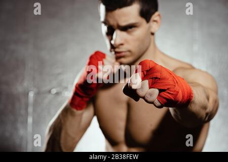 Sportboxer stanzen mit Entschlossenheit und Vorsorge über silbernem Hintergrund. Konzept für Stärke, Angriff und Bewegung. kaukasisches Modell in Bewegung bringen Stockfoto