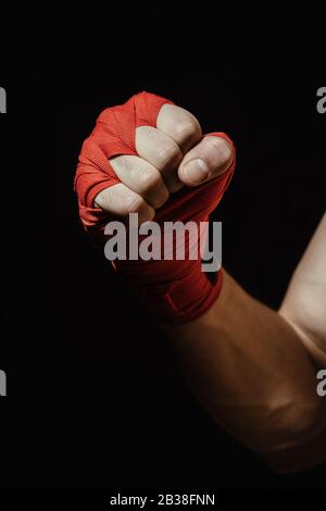 Nahaufnahme Boxerhand in rotem Verband, bereit für einen Kampf. Konzept. Starke Arme und geklemmte Fäuste Stockfoto