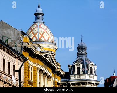 Klassische Kuppel oder Kuppel in Budapest, Ungarn. Schöne bunte Emaille-Lehmziegelüberdachung und Baudetails. Stuckierte Außenfassade mit Tympanon Stockfoto