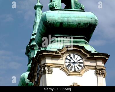 Nahaufnahme des verwitterten grünen Kupfer-Kirchturms und der weißen Budapester Kirchturmuhr. Blauer Himmel mit Wolken. Klassisches altes Architekturkonzept Stockfoto