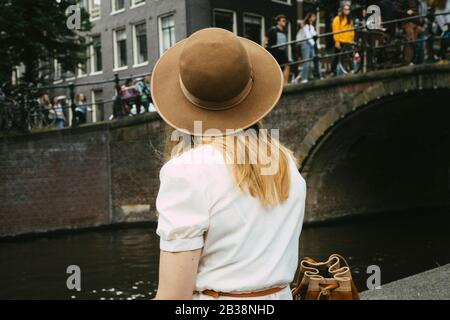 Frau in Hut mit Blick auf Kanal und Stadt Stockfoto