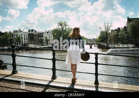Frau in weißem Kleid mit Blick auf Stadt und Kanal Stockfoto