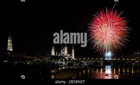 Fuegos articiciales junto a la Basilica del Pilar y La Seo, cuya luz queda reflejada en el Ebro. Este acto marca el fin de fiestas. Stockfoto