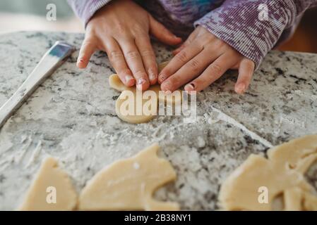 Junge Mädchen Hände auf Plätzchen Teig ausgeschnitten Stockfoto