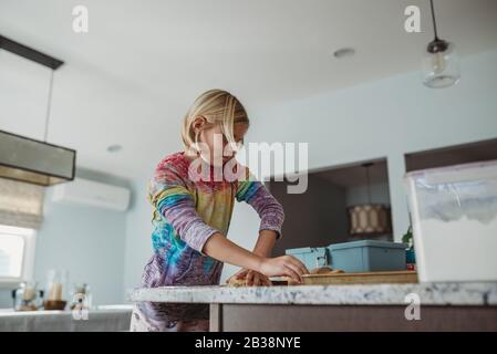 Seitenansicht eines Mädchens, das in der Küche Teig ausrollen kann Stockfoto