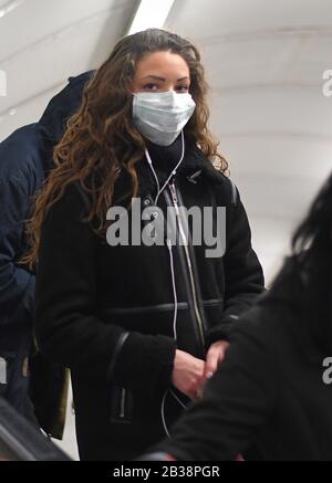 Eine Frau in der Green Park Station im U-Bahn-Netz der London Underground, die eine schützende Gesichtsmaske trägt. Stockfoto