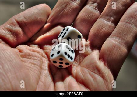 Mann mit 2 schwarzen und weißen Würfeln Stockfoto