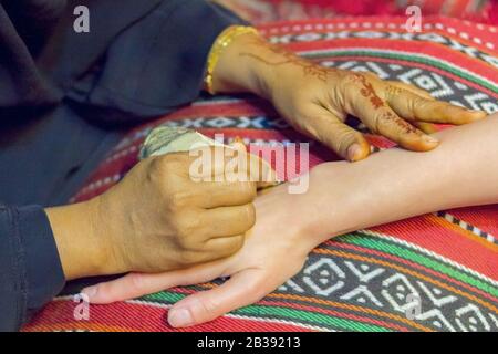 Master mehndi Henna zieht auf Eine weibliche Hand. Stockfoto