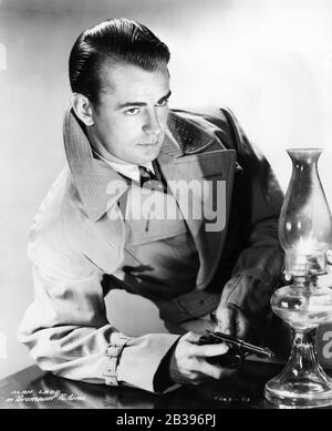 Alan LADD Posierte Publicity Portrait in Trench Coat als Philip Raven in DIESER WAFFE FÜR DEN VERLEIH des Regisseurs FRANK TUTTLE Originalromans von GRAHAM GREENE Paramount Pictures aus dem Jahr 1942 Stockfoto