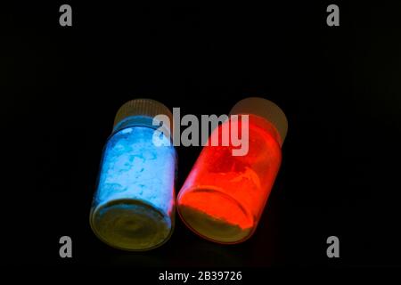 Leuchtende organische Materialien in Form eines Pulvers in zwei Glasflaschen. Stockfoto