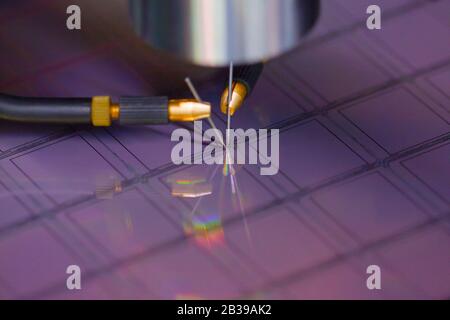 Nahaufnahme der Untersuchung einer Probe von Mikrochip-Transistor mit Sondenstation unter dem Mikroskop im Labor.EIN Halbleiter auf einem Siliziumwafer Stockfoto