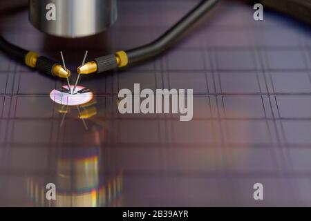 Nahaufnahme der Untersuchung einer Probe von Mikrochip-Transistor mit Sondenstation unter dem Mikroskop im Labor.EIN Halbleiter auf einem Siliziumwafer Stockfoto