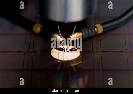 Nahaufnahme der Untersuchung einer Probe von Mikrochip-Transistor mit Sondenstation unter dem Mikroskop im Labor.EIN Halbleiter auf einem Siliziumwafer Stockfoto