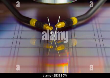 Nahaufnahme der Untersuchung einer Probe von Mikrochip-Transistor mit Sondenstation unter dem Mikroskop im Labor.EIN Halbleiter auf einem Siliziumwafer Stockfoto