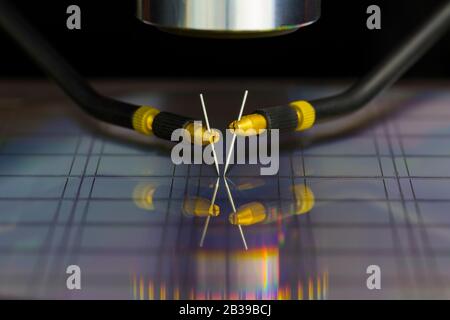 Nahaufnahme der Untersuchung einer Probe von Mikrochip-Transistor mit Sondenstation unter dem Mikroskop im Labor.EIN Halbleiter auf einem Siliziumwafer Stockfoto