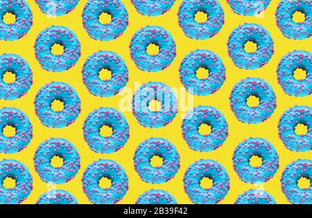 Muster eines blauen Donuts auf gelbem Hintergrund. Flaches Lay Stockfoto