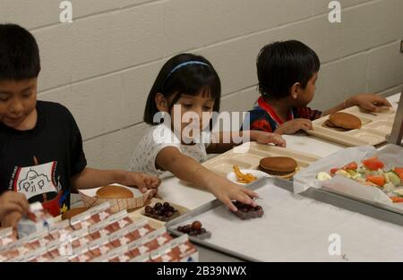 Schul-Mittagessen-Programm in Austin, TX Grundschule, wo Cafeteria Manager bemüht ist, gesunde Lebensmittel für Kindergarten und Erstklässler zu servieren. Mädchen wählt gesunde Früchte. ©Bob Daemmrich / Stockfoto