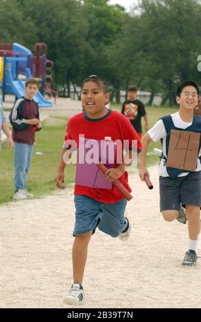 Austin Texas USA, um 2004: Jungen der vierten Klasse treten während des Leichtathletik-Tages an ihrer Grundschule im Staffellauf an. ©Bob Daemmrich Stockfoto