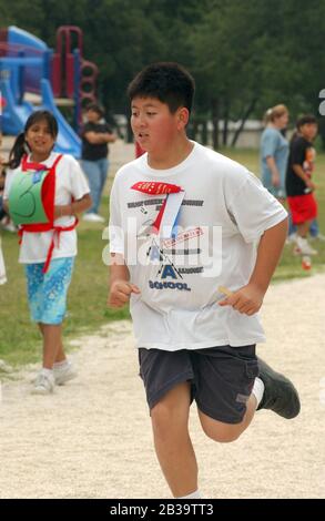 Austin Texas USA, um 2004: Die Jungen der vierten Klasse treten während des Leichtathletik-Tages an ihrer Grundschule im Mile Run gegeneinander an. ©Bob Daemmrich Stockfoto