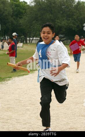 Austin Texas USA, um 2004: Jungen der vierten Klasse treten während des Leichtathletik-Tages an ihrer Grundschule im Staffellauf an. ©Bob Daemmrich Stockfoto