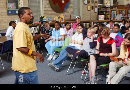 Austin Texas USA, um 2004: Schwarzer Dichter erklärt Wettbewerbsregeln vor dem Start des ersten „Poetry Slam“ für Schüler der 7. Klasse der Fulmore Junior High School in der Schulbibliothek. ©Bob Daemmrich Stockfoto