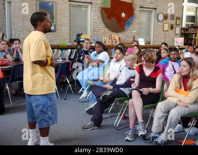 Austin Texas USA, um 2004: Schwarzer Dichter erklärt Wettbewerbsregeln vor dem Start des ersten „Poetry Slam“ für Schüler der 7. Klasse der Fulmore Junior High School in der Schulbibliothek. ©Bob Daemmrich Stockfoto