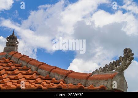 Blinkendes orangefarbenes Ziegeldach am blauen Himmel. Stockfoto