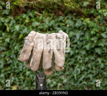 Arbeitshandschuhe am Griff einer Gartengabel Stockfoto