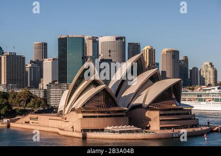 Sydney, Australien - 11. Dezember 2009: Opera House. Nahaufnahme mit den Wolkenkratzern im Rücken unter blauem Himmel. Stockfoto