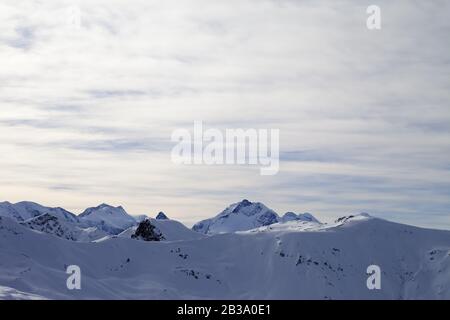 Hohe Winterberge mit schneebedeckten hängen und am Abend sonniger bewölkter Himmel. Italienische Alpen. Livigno, Region Lombardei, Italien, Europa. Stockfoto