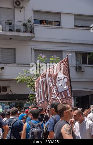 Buenos Aires, Argentinien; 10. Dezember 2019: Eine Frau putzt Häuser mit ihren Arbeitshandschuhen auf den Blick aus dem Fenster für die Mobilisierung in der Stütze und im cel Stockfoto