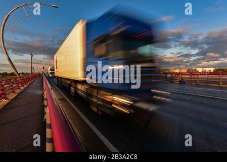 Der Lkw zieht über das Zugpendel und zieht eine schwere Last dahinter und eilt, um dem Kunden die Last rechtzeitig zu liefern. Stockfoto