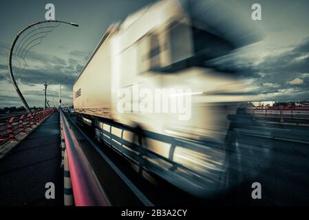 Der Lkw zieht über das Zugpendel und zieht eine schwere Last dahinter und eilt, um dem Kunden die Last rechtzeitig zu liefern. Stockfoto