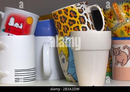 Verschiedene bunte Teetassen in einem Schrank Stockfoto