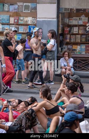 Buenos Aires, Argentinien; 10. Dezember 2019: Menschen, die auf dem Boden ruhen und eine Person, die während des Mo mit einer Maske des präsidenten in Annahme geht Stockfoto