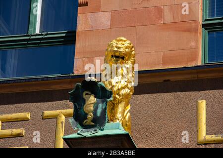 Malmö, Schweden - 11. Juli 2018: Diese goldene Löwenskulptur ist an der Fassade der sehr alten Apotheke namens Apoteket Lejonet angebracht Stockfoto
