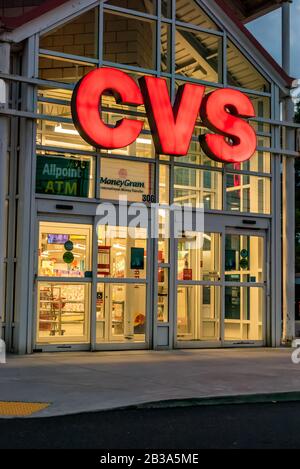 Charlotte, NC/USA - 10. Mai 2019: Glasfassade und Eingang zur "CVS Pharmacy", die hell erleuchtete große Markenbriefe in rot-beleuchtetem Innenraum zeigen. Stockfoto