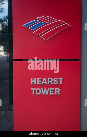 Charlotte, NC/USA - 26. Mai 2019: Doppeltes Seitenbahnschild in Rot mit "Bank of America"-Logo auf dem oberen Teil und "Hearst Tower" auf dem unteren Teil. Stockfoto