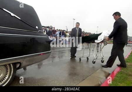 Cedar Park, Texas 07 MAR 2001: Eine von Studenten geführte Produktion von „Shattered Dreams“ mit dem simulierten Drama eines Teenagerunfalls, der im Rausch war (DUI), komplett mit Polizisten, Krankenwagen, medizinischem Evakuierungshubschrauber und einem Leichenwagen, wurde an der Cedar Park High School inszeniert, um Schülern zu helfen, nicht zu trinken und zu fahren. An der Produktion nahmen Dutzende von Studenten als Unfallopfer, Berater und weinende Verwandte Teil, darunter eine Beerdigungs-Produktion mit Schatullen und trauernden Eltern. Hier laden Hausangestellte einen „toten“ Studenten in einen Leichenwagen außerhalb der Schule. ©Bob Daemmrich Stockfoto