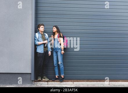 Junge und brünette Teenager, rauchen Zigarette und halten Bier Stockfoto