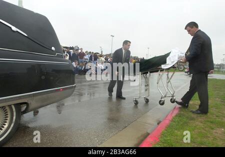 Cedar Park, Texas 07 MAR 2001: Eine von Studenten geführte Produktion von „Shattered Dreams“ mit dem simulierten Drama eines Teenagerunfalls, der im Rausch war (DUI), komplett mit Polizisten, Krankenwagen, medizinischem Evakuierungshubschrauber und einem Leichenwagen, wurde an der Cedar Park High School inszeniert, um Schülern zu helfen, nicht zu trinken und zu fahren. An der Produktion nahmen Dutzende von Studenten als Unfallopfer, Berater und weinende Verwandte Teil, darunter eine Beerdigungs-Produktion mit Schatullen und trauernden Eltern. Hier laden Hausangestellte einen „toten“ Studenten in einen Leichenwagen außerhalb der Schule. ©Bob Daemmrich Stockfoto