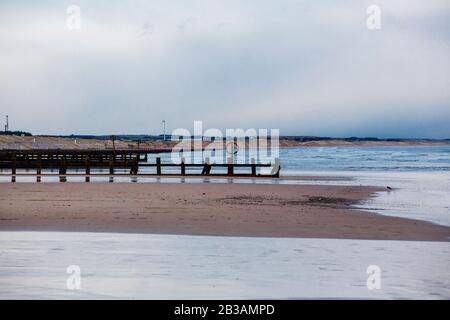 Blick auf den Aberdeen Beach im Winter, seinen goldenen Sand und seine lange geschwungene Länge zwischen dem Hafen und der Flussmünde des Don und seinen vielen Ozeangroynes Stockfoto