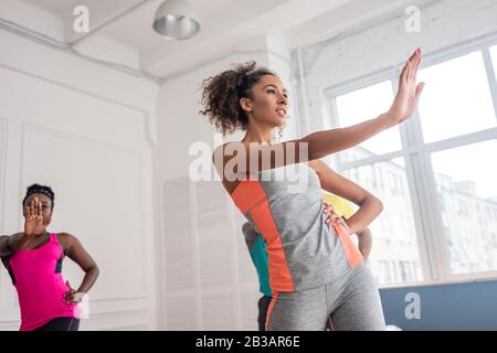 Niedriger Blickwinkel auf afroamerikanische Tänzerinnen, die zumba im Tanzstudio praktizieren Stockfoto