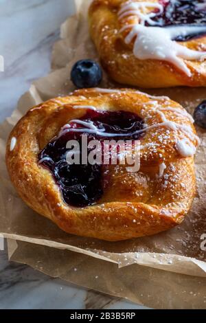 Blaubeere, glasierte dänische Dessertgebäcke mit Puderteis und Puderzucker Stockfoto